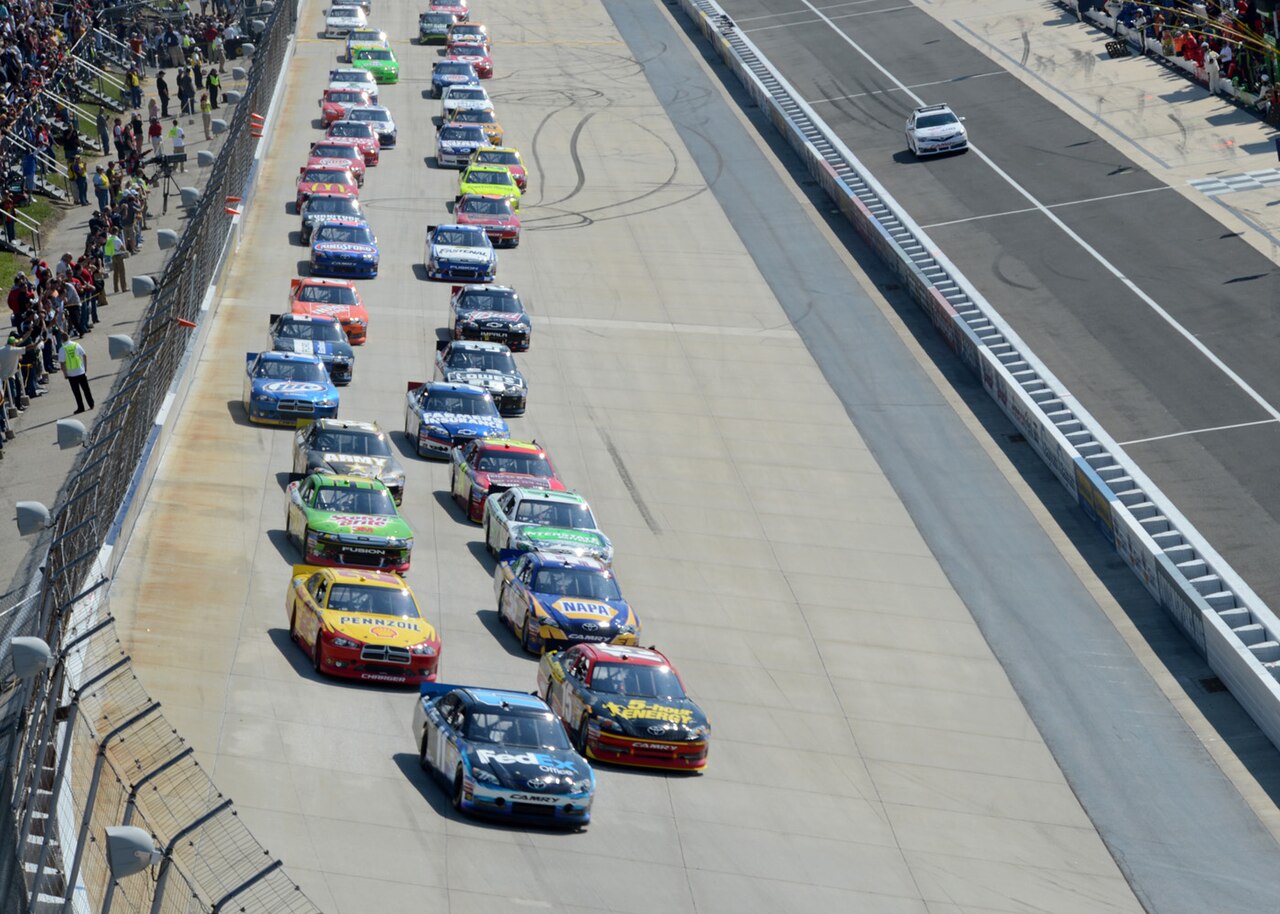 Dover Motor Speedway — Denny Hamlin, driver of the No. 11 Fed Ex Toyota, leads the drivers into Turn 1 at the start of the NASCAR Sprint Cup Series AAA 400 Sept. 3